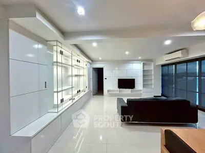 Spacious modern living room with sleek white cabinetry and large windows