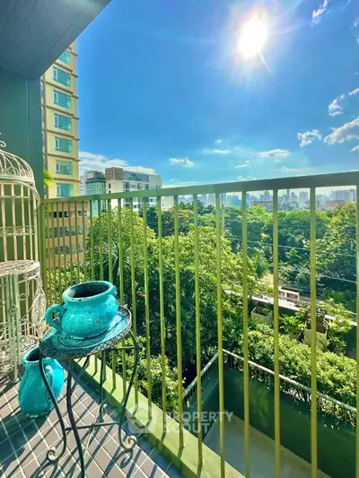 Stunning balcony view with lush greenery and city skyline under a bright sunny sky.