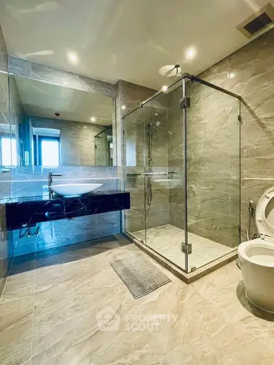 Luxurious modern bathroom with glass shower and elegant marble tiles