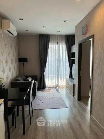 Modern living room with stylish decor and natural light, featuring a cozy seating area and elegant flooring.