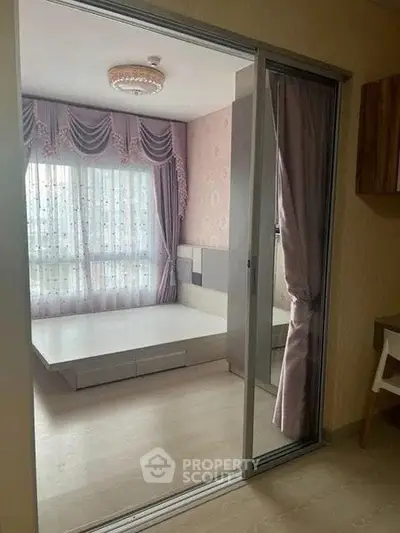 Elegant bedroom with sliding glass doors and stylish curtains in modern apartment.