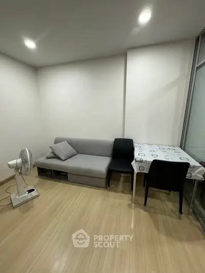 Cozy living room with modern sofa and dining area, perfect for small apartments.