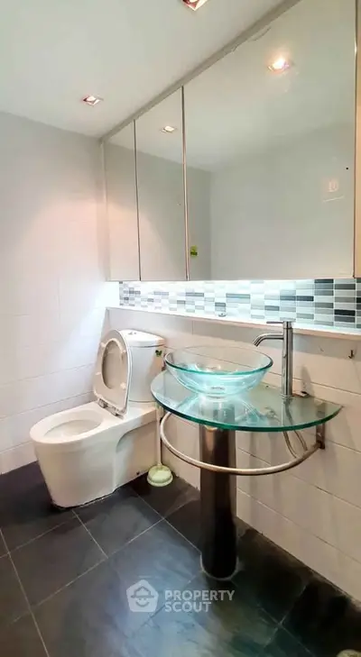 Modern bathroom with glass sink and stylish tile accents