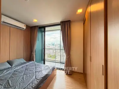 Modern bedroom with city view and balcony access in high-rise apartment