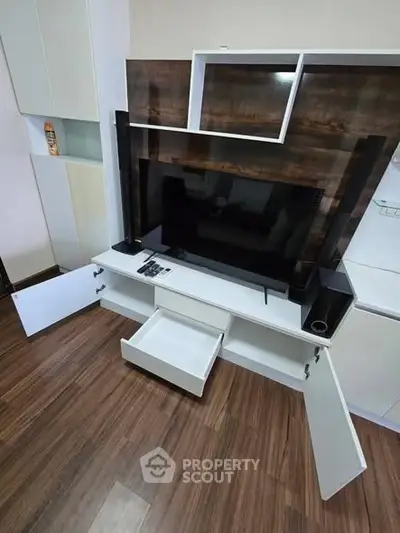 Modern living room with sleek TV unit and wooden flooring