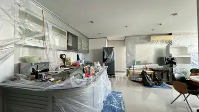 Spacious kitchen and living area under renovation with modern cabinets and appliances.