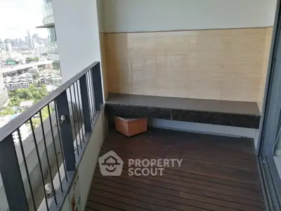 Spacious balcony with city view and wooden flooring in modern apartment.