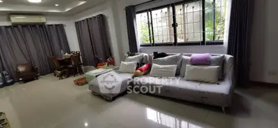Spacious living room with modern sofa and large windows, perfect for relaxation and entertaining.