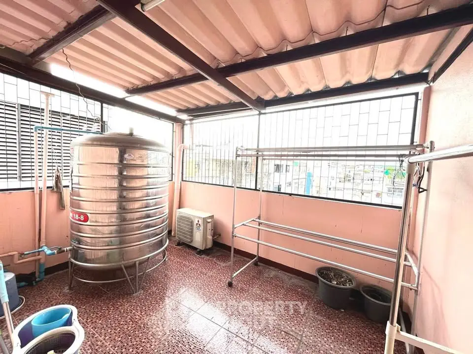 Spacious rooftop with water tank and laundry area in urban setting