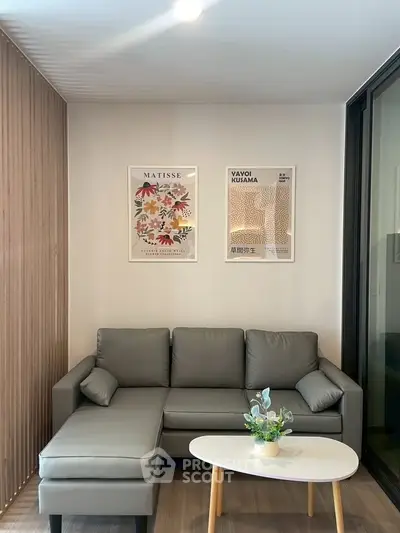 Modern living room with stylish gray sofa, wooden accents, and artistic wall decor.