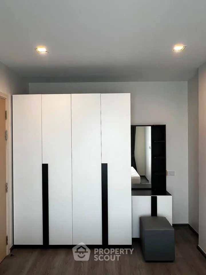 Modern bedroom with sleek wardrobe and vanity in minimalist design