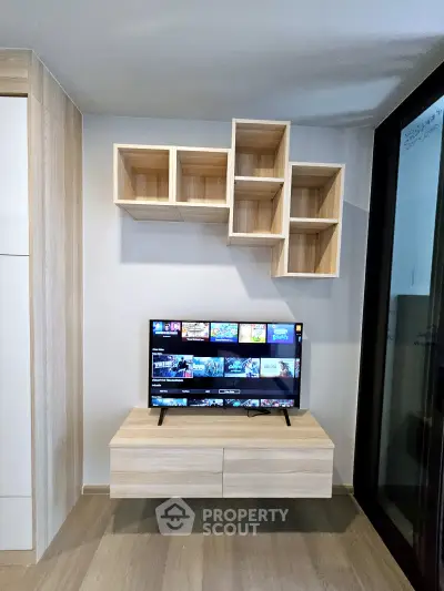 Modern living room with stylish wooden TV stand and wall-mounted shelves, perfect for contemporary urban living.