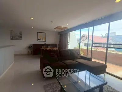 Spacious living room with modern furniture and large windows offering a scenic view.
