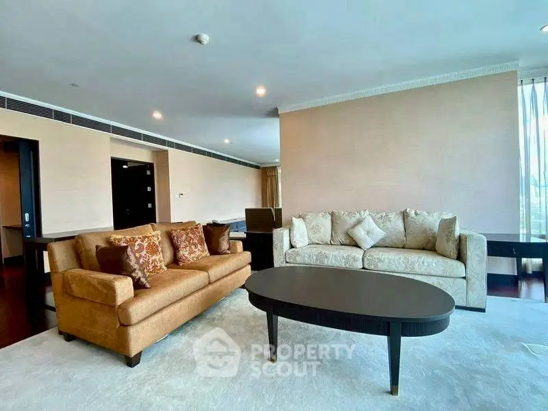 Luxurious living room with elegant sofas and modern decor in a spacious apartment.