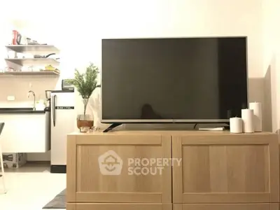 Modern living room with sleek TV and stylish kitchen in open layout