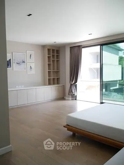 Spacious modern bedroom with large window and minimalist decor