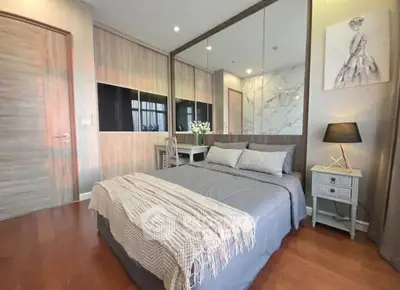 Elegant bedroom with modern decor, featuring a cozy bed, stylish artwork, and warm lighting.