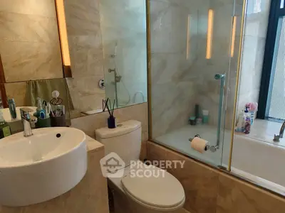 Modern bathroom with glass shower and elegant fixtures in luxury apartment.
