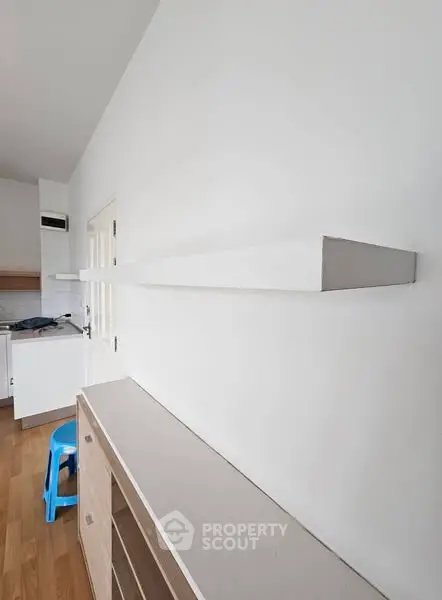 Minimalist kitchen with white shelves and wooden flooring