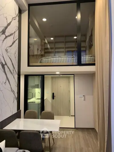 Modern loft apartment with mezzanine bedroom and stylish dining area, featuring marble accents and sleek design.