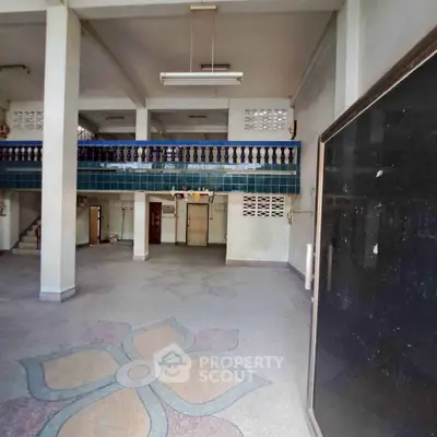 Spacious interior with decorative flooring and mezzanine level, ideal for creative renovation.