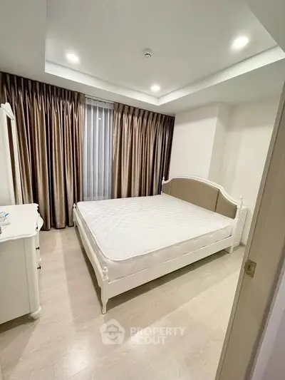 Elegant bedroom with classic white furniture and soft lighting, perfect for a cozy retreat.