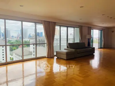 Spacious living room with panoramic city views and elegant hardwood flooring.