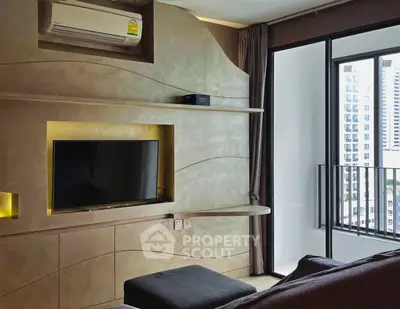 Modern living room with sleek TV setup and balcony view in urban apartment