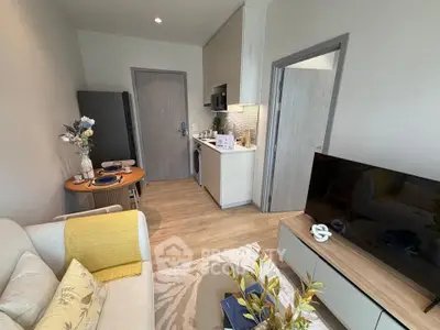 Modern living room with open kitchen, stylish decor, and cozy dining area in a compact apartment.