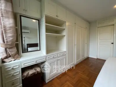 Spacious bedroom with elegant built-in wardrobe and parquet flooring