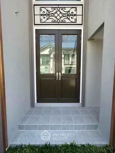 Elegant entrance with double doors and decorative transom window