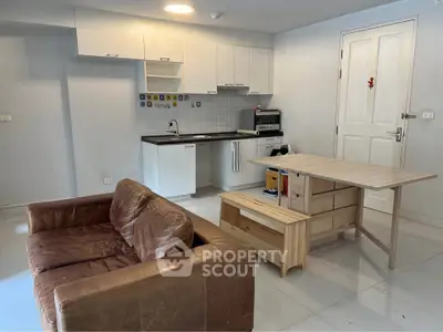 Cozy apartment with open kitchen layout and leather sofa in modern living space.