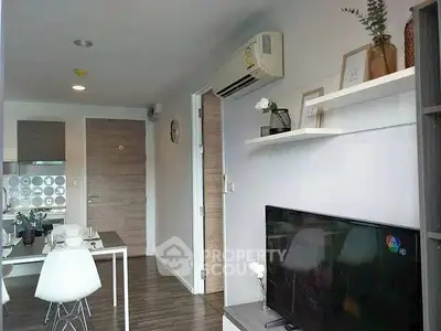 Modern living room with sleek decor and dining area in open layout apartment.