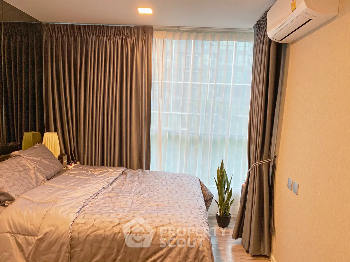 Cozy bedroom with modern decor and large window for natural light