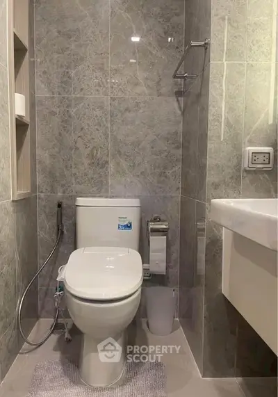 Modern bathroom with sleek gray tiles and contemporary fixtures.