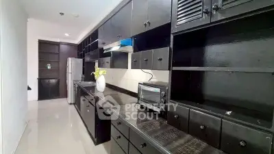 Spacious kitchen with sleek black cabinetry and modern appliances