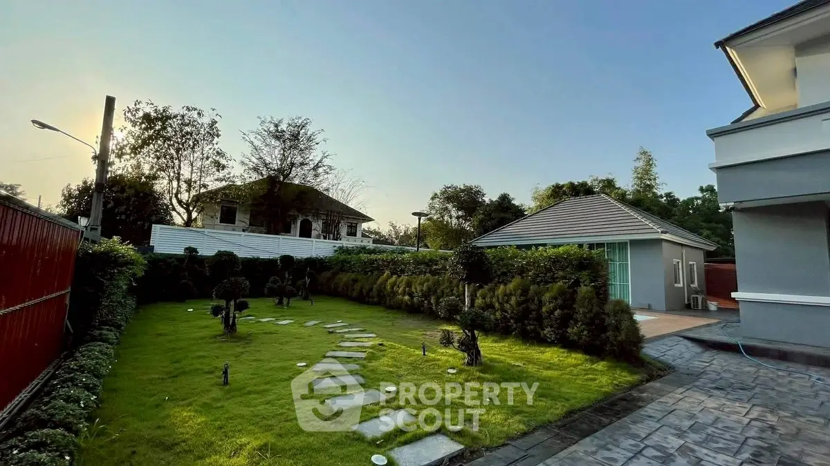 Charming garden view with lush greenery and modern house exterior, perfect for serene living.