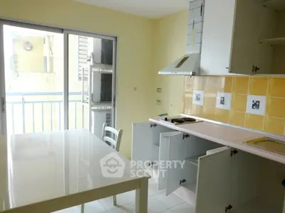 Bright kitchen with open cabinets and balcony access