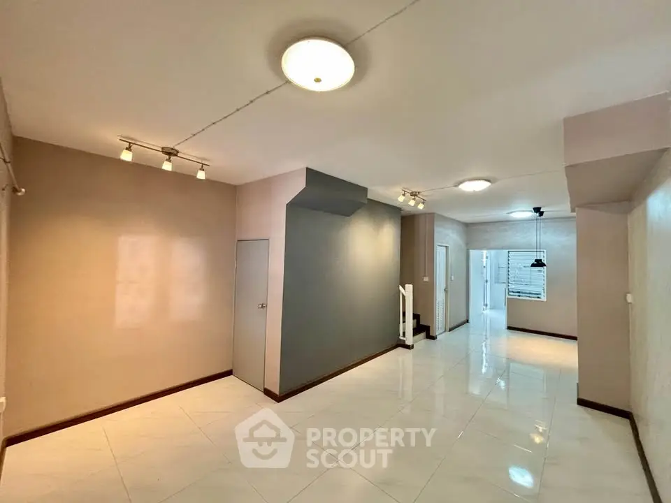 Spacious open layout living area with modern lighting and tiled flooring