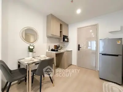 Modern kitchen with dining area, featuring sleek cabinetry and stainless steel appliances.