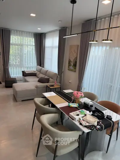 Spacious modern living room with elegant dining area and large windows for natural light.