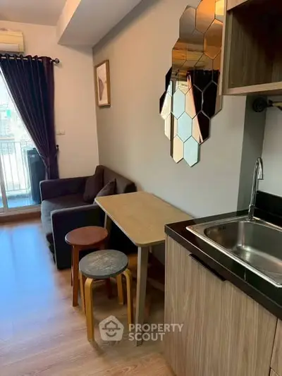 Modern compact living room with kitchenette and balcony view