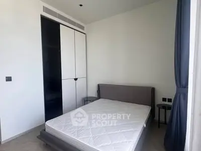 Modern minimalist bedroom with sleek design and ample natural light.