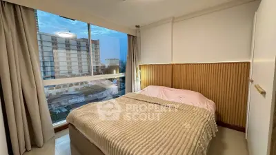 Cozy bedroom with large window offering stunning city view