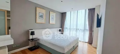 Spacious modern bedroom with large window and elegant decor in a high-rise apartment.