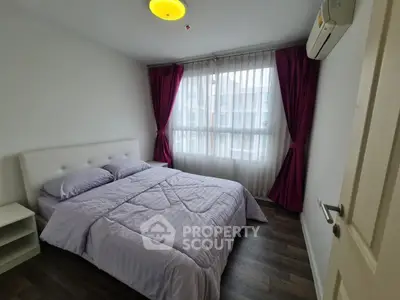 Cozy bedroom with modern decor and large window, featuring elegant purple curtains and a comfortable bed.
