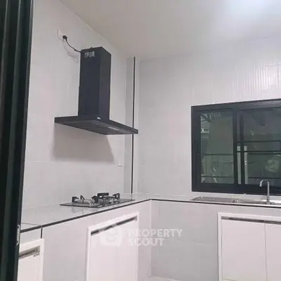 Modern kitchen with sleek design, featuring a gas stove and ample counter space.