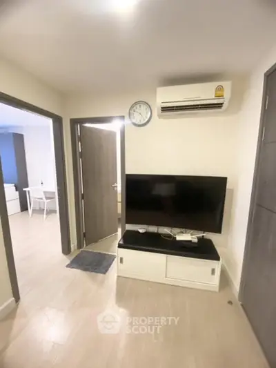 Modern living room with sleek TV setup and air conditioning in a cozy apartment.