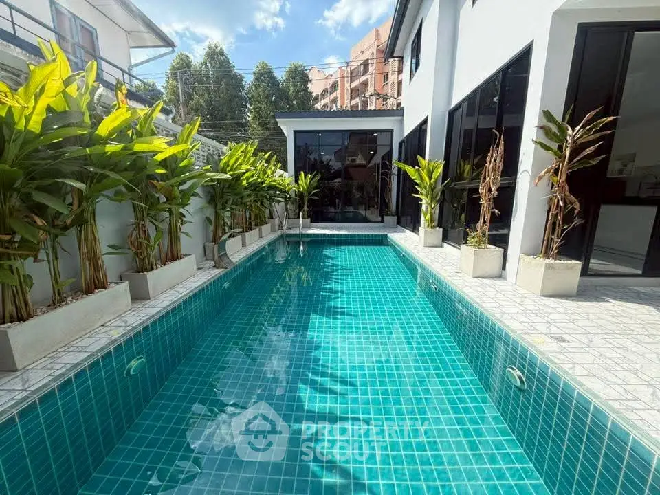 Stunning modern home with a luxurious private pool and lush greenery, perfect for relaxation and entertainment.