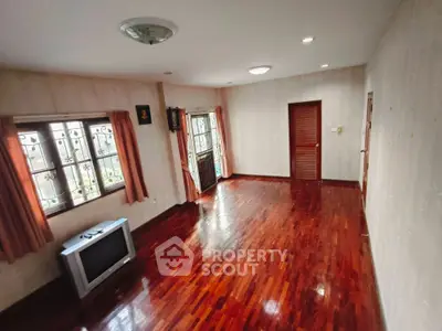 Spacious living room with wooden flooring and natural light